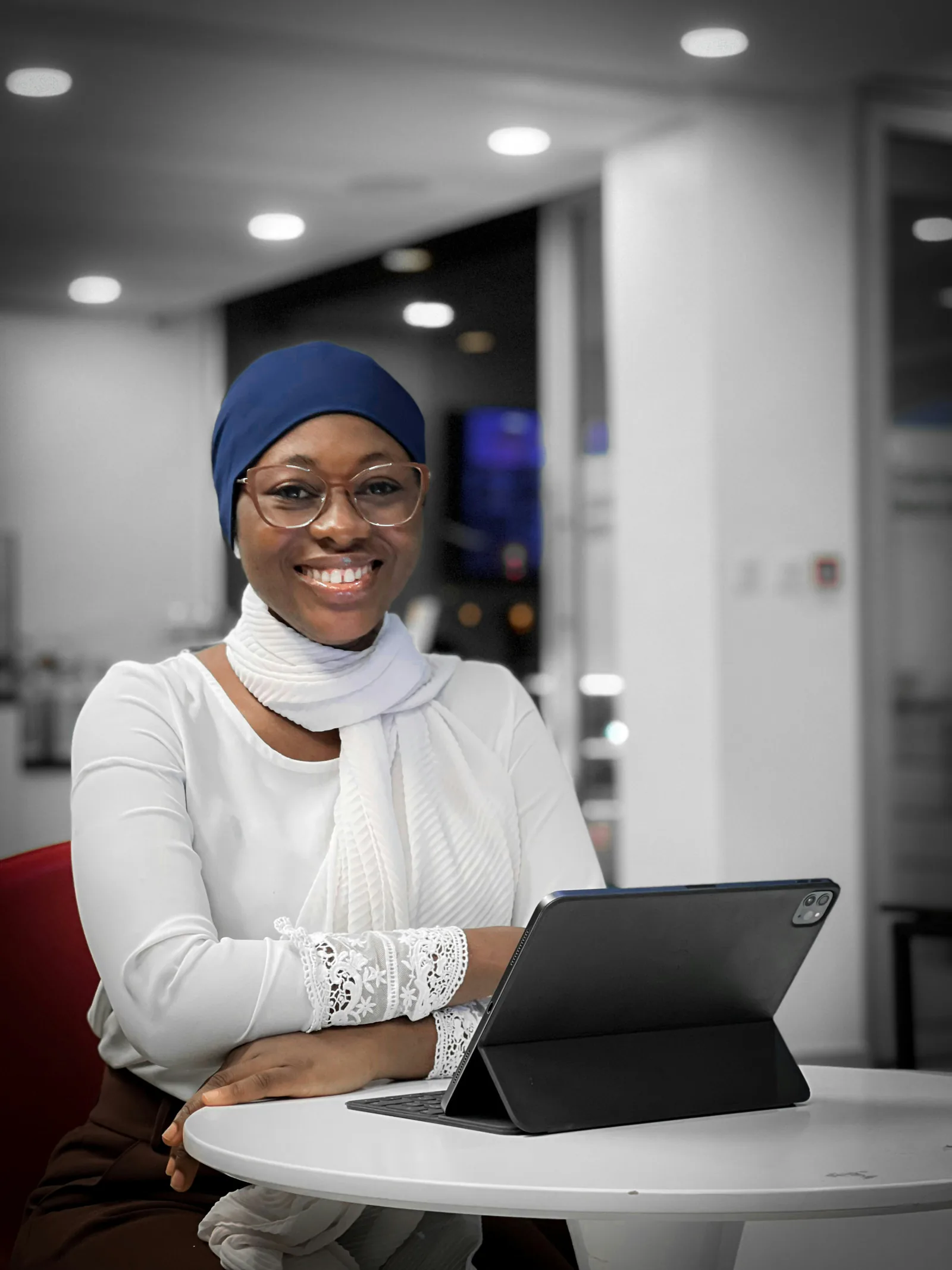 Freelancer wearing a blue headscarf and glasses with a tablet